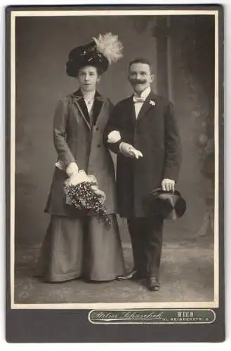 Fotografie Atelier Schaschek, Wien, österreichisches Brautpaar im Kleid mit Brautstrauss und im Anzug mit Zylinder