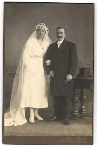 Fotografie Atelier Münch, Strassburg i. E., Ehepaar im Hochzeitskleid mit Schleier und im Anzug nebst Zylinder