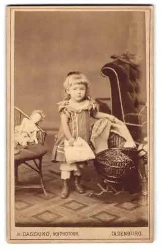 Fotografie H. DAseking, Oldenburg i. O., niedliches kleines Mädchen im Kleid nebst ihrer Puppe auf dem Stuhl