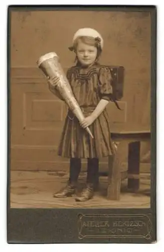 Fotografie Atelier Hertzsch, Leisnig, junges Mädchen zur Einschulung mit Zuckertüte und Ranzen