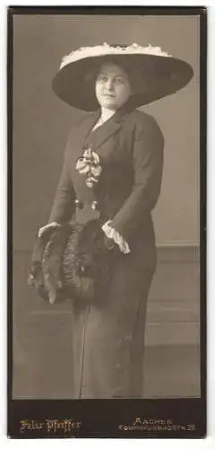 Fotografie Gebr. Pfeiffer, Aachen, junge Dame im dunklen Kleid mit Muff und breitkrempigen Hut