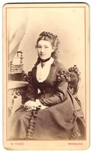 Fotografie W. Risse, Marburg / Lahn, junge Frau im Kleid mit geflochtenen hochgesteckten Haaren