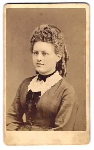 Fotografie Wilhelm Ernst, Hannover, Junge Frau im Kleid mit Korkenzieherlocken