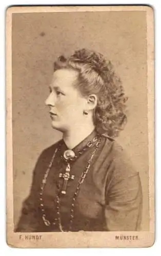 Fotografie F. Hundt, Münster i. W., junge Dame im Kleid mit Kruzifix und Locken