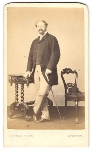 Fotografie Hughes, Ryde i. W., englischer Herr im Anzug mit Flanierstock und Melone auf dem Stuhl