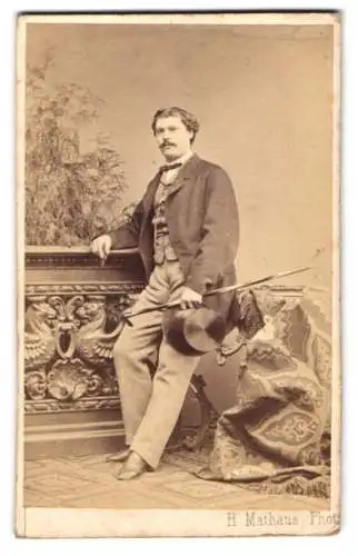 Fotografie H. Mathaus, München, Portrait Herr Gustav Zeller im Anzug mit Zylinder und Stock