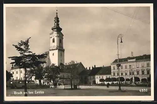 AK Bruck a. d. Leitha, Strassenpartie mit Kirche