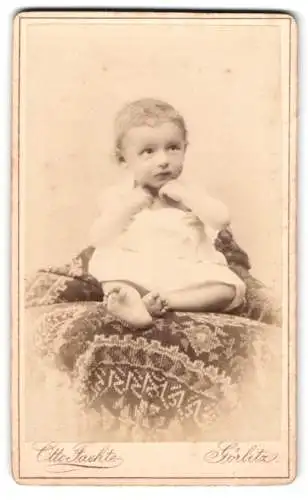 Fotografie Otto Faethe, Görlitz, Grüner Graben 29, Kleines Kind im weissen Gewand auf einer gemusterten Decke