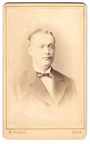 Fotografie W. Fechner, Berlin, Krausen-Str. 21, Junger Mann im Anzug mit feiner Fliege und Schnurrbart