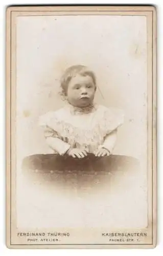 Fotografie Ferdinand Thüring, Kaiserslautern, Fackelstr. 1, Niedliches Kind im weissen Kleid mit Spitze und Schmollmund