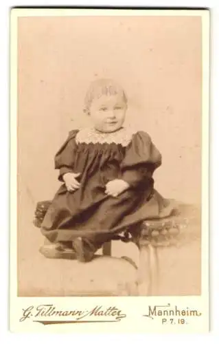 Fotografie G. Tillmann-Matter, Mannheim, Heidelbergerstr. 19, Süsses Kleinkind im schwarzen Kleid mit weisser Spitze