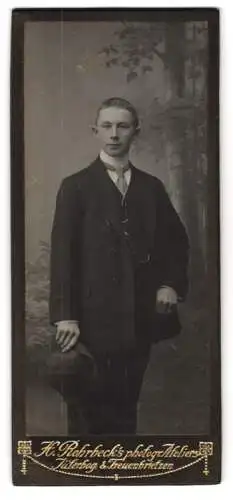 Fotografie H. Rohrbeck, Jüterbog, Junger Mann im Anzug mit einer Krawatte und seinem Hut in der Hand