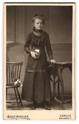 Fotografie Adolf Winkler, Görlitz, Berlinerstr. 12, Bürgerliches Mädchen im taillierten Kleid mit einem Buch in der Hand