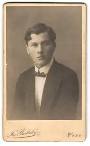 Fotografie Jos. Skalický, Písek, Junger Mann mit Seitenscheitel im Anzug mit einer kleinen Fliege