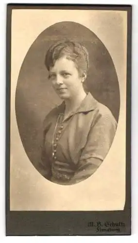 Fotografie M. B. Schultz, Flensburg, Junge Frau mit aufwendig frisiertem Haar mit einem leichten Lächeln
