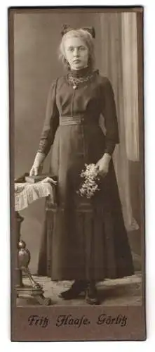 Fotografie Fritz Haase, Görlitz, Junge Frau mit Schleife im Haar, mit einem Buch und Blumen in der Hand