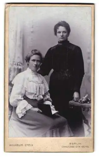 Fotografie Wilhelm Stein, Berlin, Chaussee Str. 65 /66, Zwei bürgerliche Damen in feinen Kleidern, eine mit einem Buch