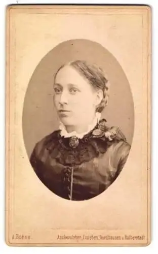 Fotografie A. Bohne, Aschersleben, Markt 25, Junge Frau mit zurückgeflochtenem Haar und einer Brosche am Kragen