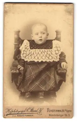 Fotografie C. Steinl. Nf., Fürstenwalde a. Spree, Müncheberger-Str. 9, Kleines Kind mit kurzgeschorenen Haaren im Kleid
