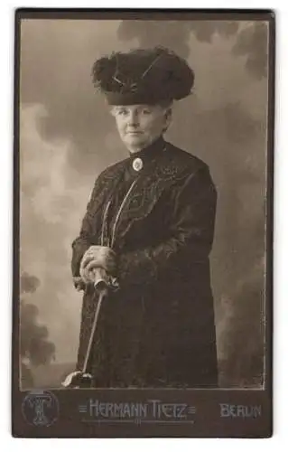 Fotografie Hermann Tietz, Berlin, Leipziger Str., Ältere Dame mit markantem Hut und einem Sonnenschirm