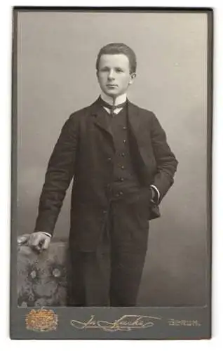 Fotografie J. Fuchs, Berlin, Königstrasse 52, Junger Mann im Anzug mit einer Krawatte und pomadisiertem Haar