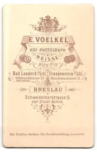 Fotografie E. Voelkel, Neisse, Ring 18, Junge Dame mit lockigem Haar und schwarzer Zierbluse unterm Kleid