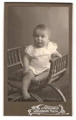 Fotografie J. Hirschbeck, Landsberg a. Lech, Kleinkind im weissen Gewand auf einem Kleinen Stuhl