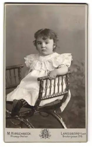 Fotografie M. Hirschbeck, Landsberg a. Lech, Brudergasse 216, Kleines Mädchen im weissen Kleid auf einem kleinen Stuhl