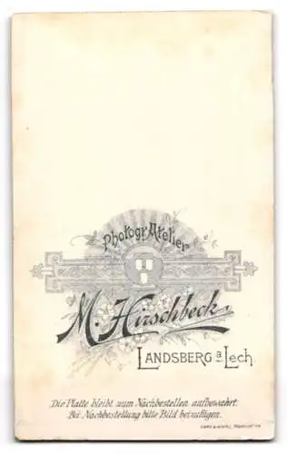Fotografie M. Hirschbeck, Landsberg a. Lech, Jugendlicher Knabe im Anzug mit weisser Krawatte, mit leichtem Schnäuzer