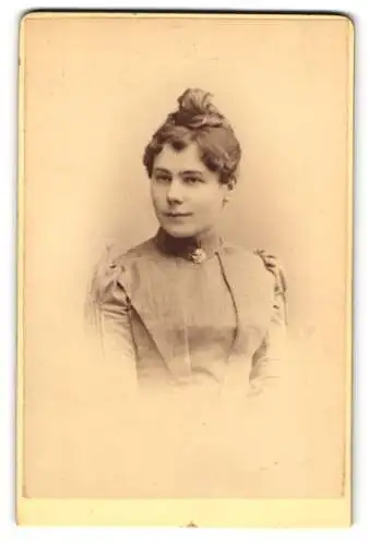 Fotografie Karl Lützel, München, Dachauerstr. 19, Junge Dame im Kleid mit Brosche am Kragen und leichten Puffärmeln