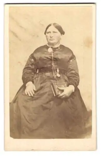 Fotografie unbekannter Fotograf und Ort, Bürgerliche Dame im schwarzen Kleid mit grosser Brosche am Kragen