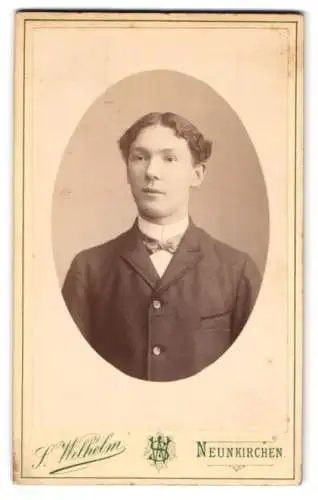 Fotografie S. Wilhelm, Neunkirchen, Junger Mann mit welligem Mittelscheitel im Anzug mit Fliege