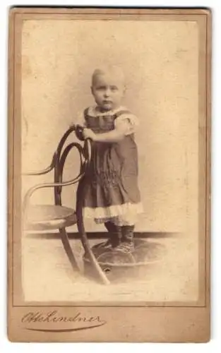 Fotografie Otto Lindner, Berlin, König-Str. 31, Kleinkind in einem Kleid mit Rüschen-Elementen auf einem Polster