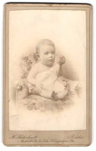 Fotografie H. Haberlandt, Berlin, Anhalt Str. 2, Kleindkind im weissen Gewand auf einem Sessel, mit gebanntem Blick