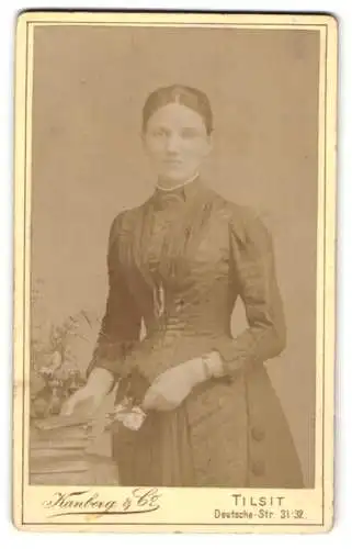 Fotografie Kanberg & Co., Tilsit, Deutsche-Str. 31-32, Junge Dame im edlen taillierten Kleid mit einer Blume in der Hand