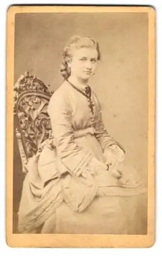 Fotografie G. Friedrich, Prenzlau, Baustrasse 326, Junge Frau im Kleid mit grossem Kreuzanhänger, auf einem Stuhl