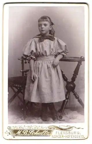 Fotografie M. B. Schultz, Flensburg, Norder Hofenden 13, Junges Mädchen im gestreiften Kleid mit Schleife am Kragen