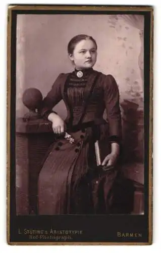 Fotografie L. Stüting, Barmen, Bahnhofstrasse 6, Jugendliches Mädchen im taillierten Kleid mit einem Buch