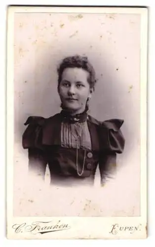 Fotografie C. Franken, Eupen, Neustrasse, Junge Frau im taillierten Kleid mit gepufften Schultern und Brosche am Kragen