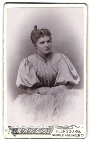 Fotografie M. B. Schultz, Flensburg, Norder-Hofenden 13, Junge Frau im Kleid mit Puffärmeln mit einer Haarnadel