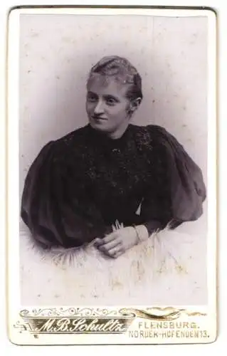 Fotografie M. B. Schultz, Flensburg, Norder-Hofenden 13, Junge Frau im schwarzen Kleid mit Puffärmeln mit welligem Haar