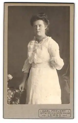 Fotografie Karl Frevert, Lemgo, Bismarckstr., Bürgerliche Dame im weissen Kleid mit einer Hand hinterm Rücken