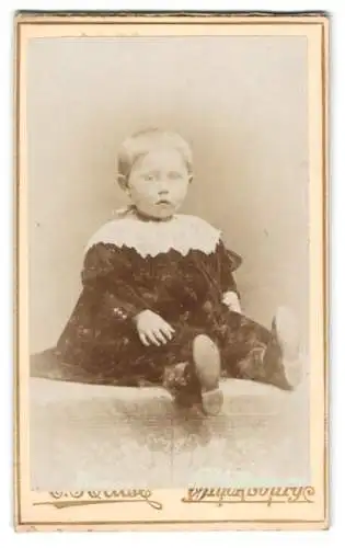 Fotografie unbekannter Fotograf und Ort, Kleines Kind im schwarzen Gewand mit weisser Kragenpartie, mit abwartendem Blick