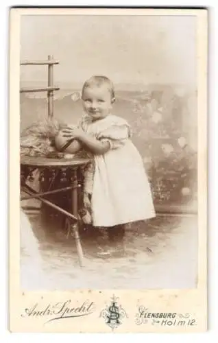 Fotografie Andr. Specht, Flensburg, Holm 12, Kleines Kind im weissen Kleid mit einem Spielball