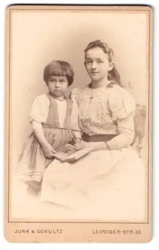 Fotografie Junk & Schultz, Berlin, Leipziger-Str. 35, Jugendliches Mädchen im gepunkteten Kleid mit kleiner Schwester
