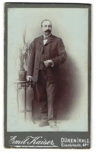 Fotografie Emil Kaiser, Düren, Eisenbahnstr. 48, Junger Herr im schwarzen Anzug mit gezwirbeltem Schnurrbart und Fliege