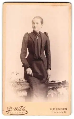 Fotografie B. Wehle, Dresden, Marienstr. 44, Junge Dame im schwarzen Kleid mit Fächer und Silberkette