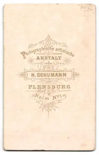 Fotografie H. Schumann, Flensburg, Holm 1, Junge Dame lehnt im schwarzen taillierten Kleid an einem Stuhl