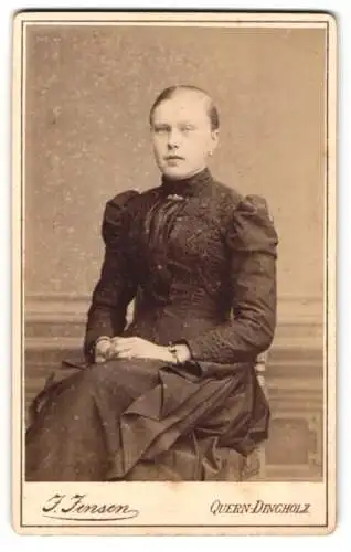 Fotografie J. Jensen, Quern-Dingholz, Junge elegante Dame im schwarzen Kleid mit Spitzenmuster und Brosche