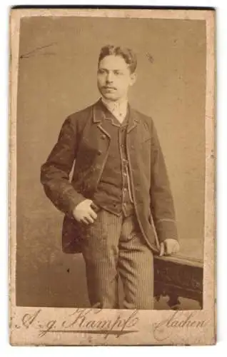 Fotografie Aug. Kampf, Aachen, Theaterstr. 3, Junger Herr im Anzug mit gestreifter Hose und Mittelscheitellocken